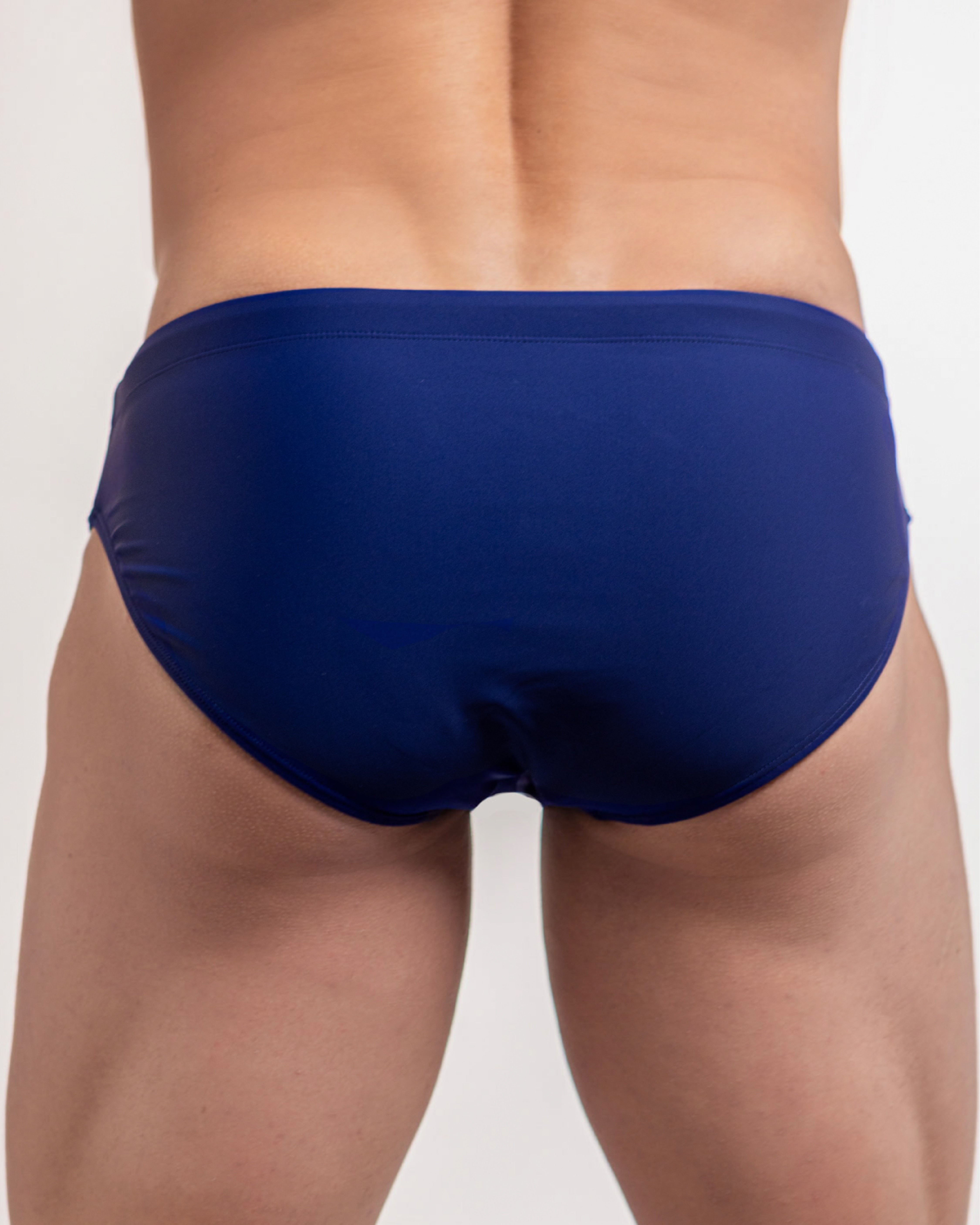 Blue swim briefs worn by a person on a plain background